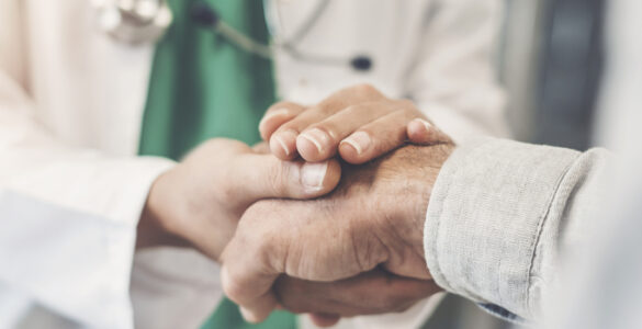 Hospital worker holding a patient's hand