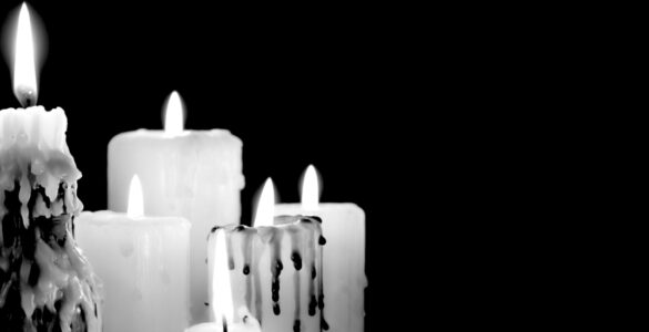 5 candles burning against a black background