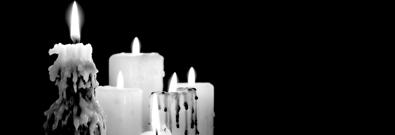 5 candles burning against a black background