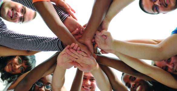 Multiple hands together in a huddle