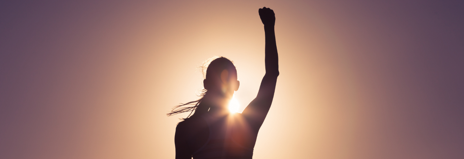 Outline of woman in sun with arm up