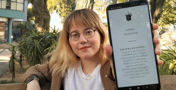 Nichola holding a phone showing Palavra Escocesa
