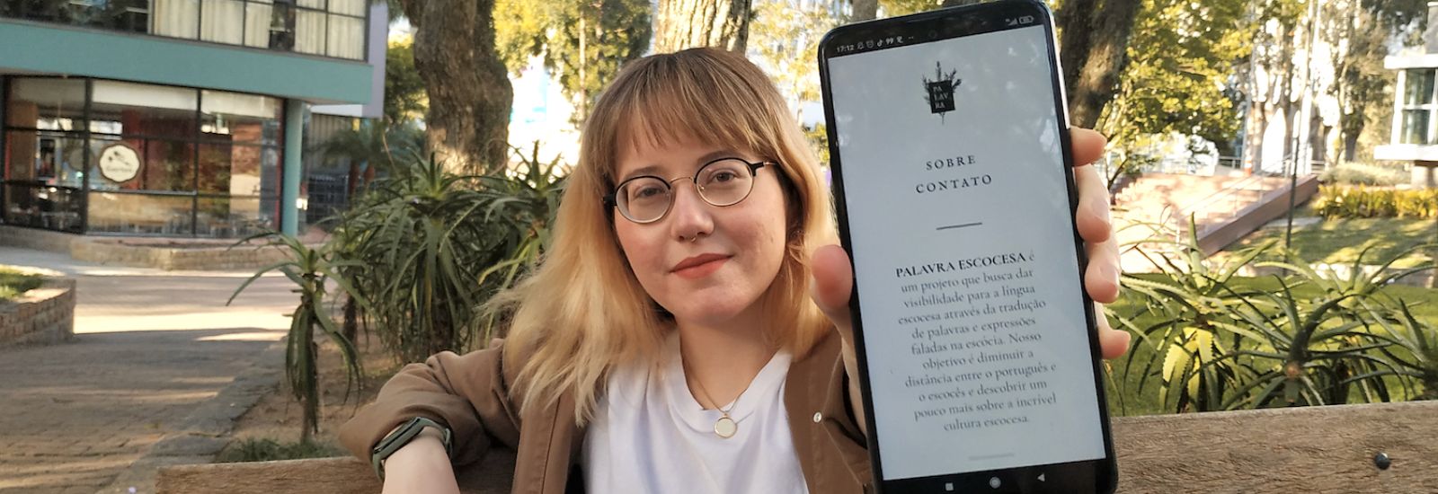 Nichola holding a phone showing Palavra Escocesa