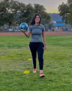 Faid on a field holding a football