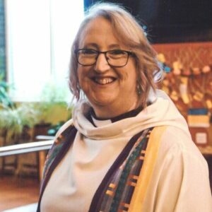 Reverend Anne Day smiling at the camera in her robes