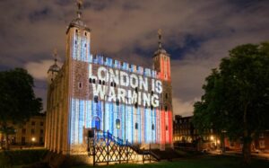 Tower of London with the climate stripes projected onto it.