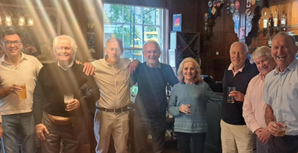 Alumni with arms around shoulders, smiling inside Park House