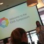 Emma Mayhew welcomes attendees at the EMA symposium