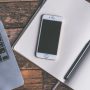 A picture of a phone and laptop with blank screens in a study environment.