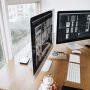 Dual computer screens side by side on a desk.
